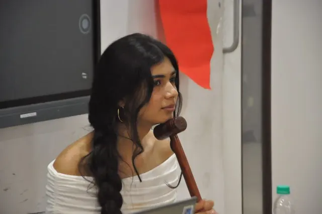 A chair listens with the gavel in hand.