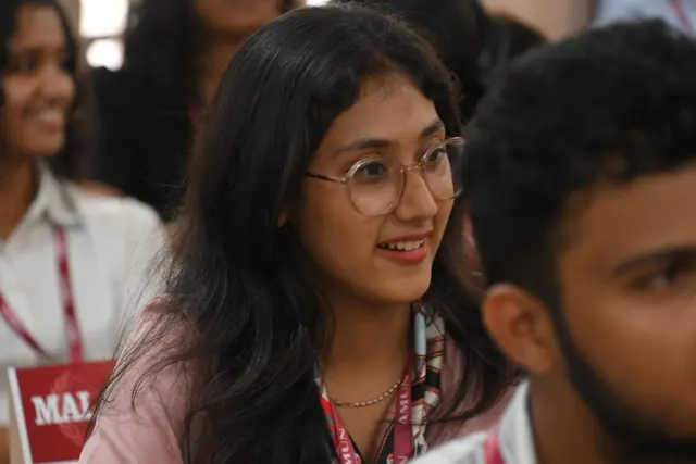 A delegate smiles across the room.