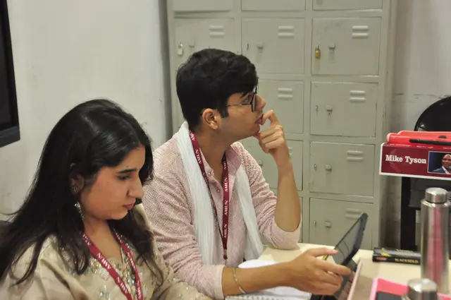 Two delegates follow the debate.