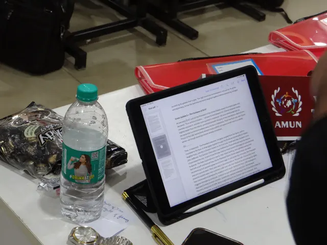 A delegate’s desk: a tablet, notes and the AMUN placard.