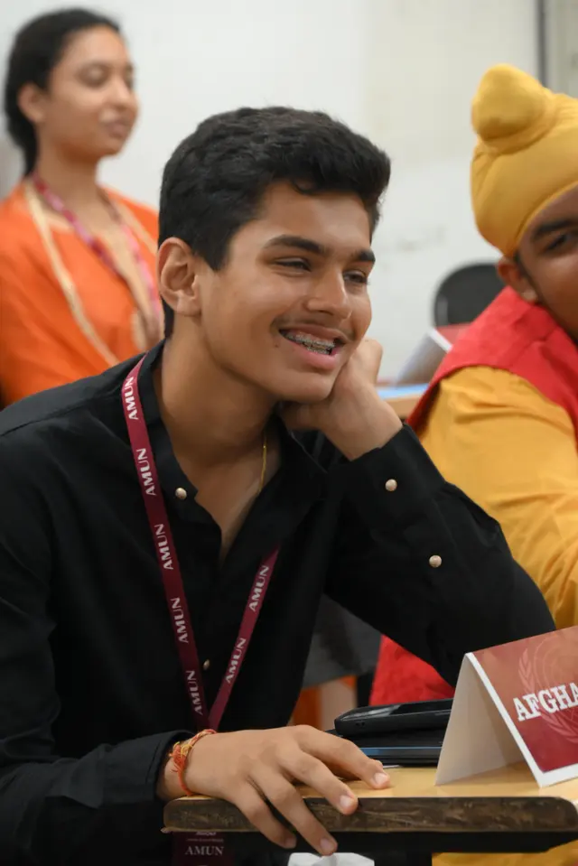 Delegates share a joke at their desks.