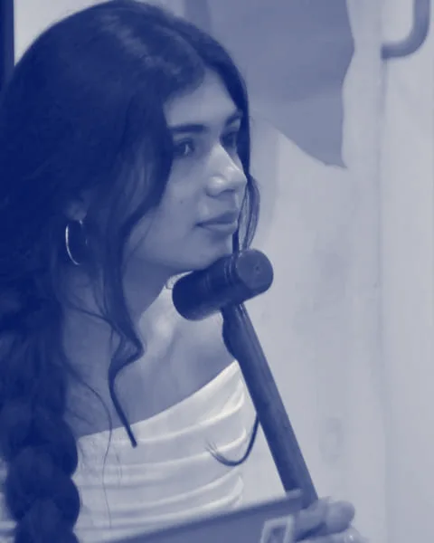 A committee chair resting a wooden gavel against her chin as she listens.