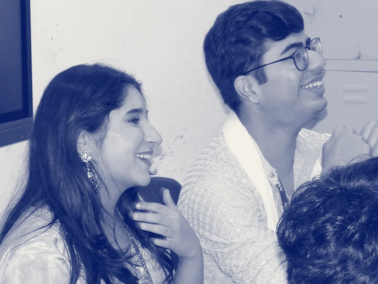 Two delegates laughing at their desks during a session.